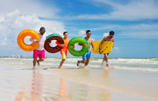 istock Running with inflatable ring tubes on a beach in Miami 1266886332