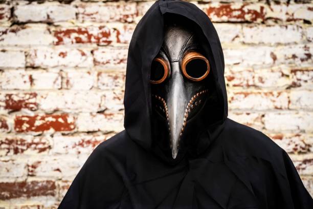Sinister character doctor wearing an old time pandemic protective face mask Sinister character doctor wearing an old time pandemic protective face mask because Covid-19 pandemic black plague doctor stock pictures, royalty-free photos & images