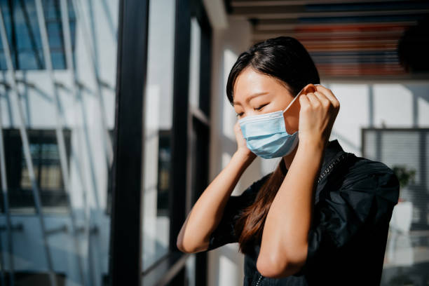 istock Young Asian woman wearing protective face mask 1266889655