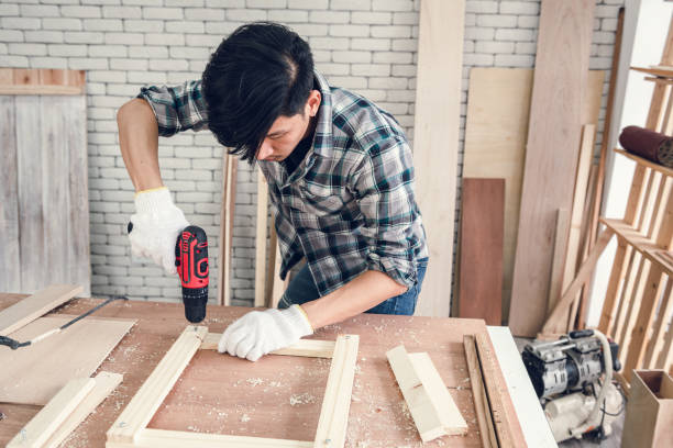 istock Carpenter Man is Working Timber Woodworking in Carpentry Workshops, Craftsman Using Screwing Equipment to Timber Plank for Wooden Furniture in Workshop. DIY Workmanship, Job Carpenters Concept 1266891498