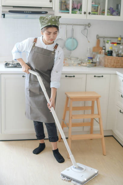 istock A young maid cleaning the house with a mop There is a kitchen backdrop 1266894644