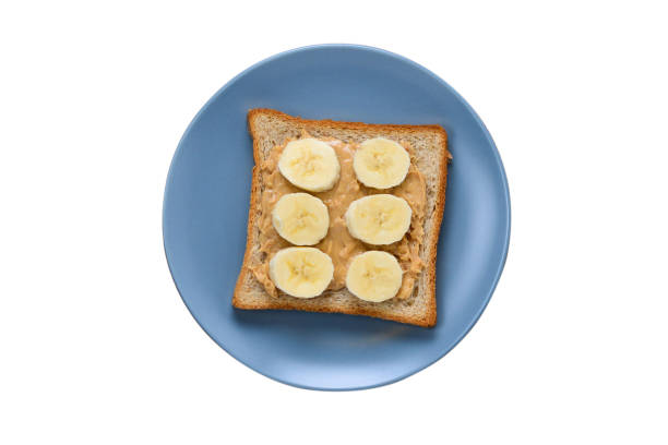 istock Peanut butter toast with banana slices isolated on white. 1266896579