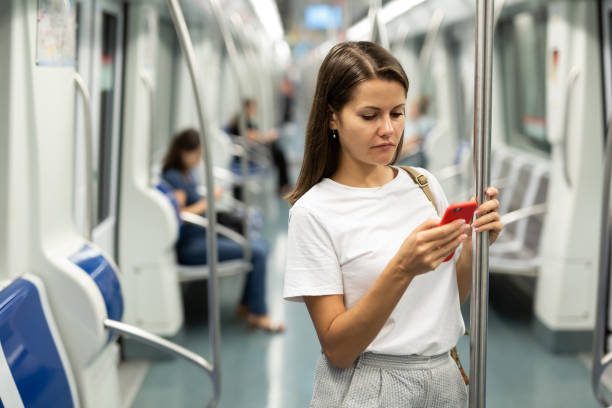 istock Woman with smartphone in subway car 1266901448