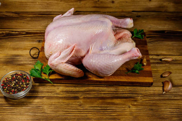 istock Raw whole chicken with spices on a wooden table 1266902195