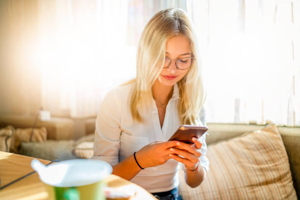 istock Young woman sitting  and uses mobile phone 1266903527