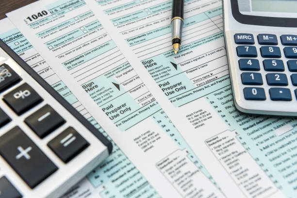 tax forms with calculator and pen. financial accounting - tax imagens e fotografias de stock