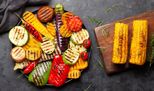 Grilled vegetables on plate with spices and herbs. Top view flat lay