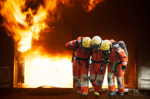 istock Firefighters are helping workers by pulling out of the burning building . 1266908774