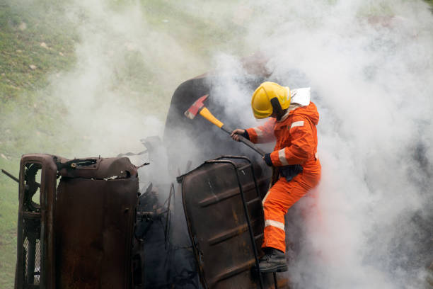 istock Firefighters using ax destroy obstacles in a burning and smoky truck.. 1266908858
