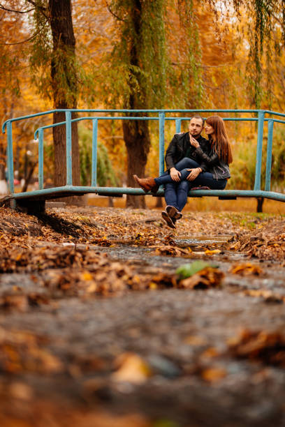 istock man and woman on bridge over stream in autumn Park 1266909621