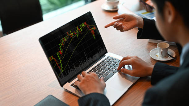 istock Business People are using a computer laptop with a candlestick chart on-screen at the meeting table. 1266909954