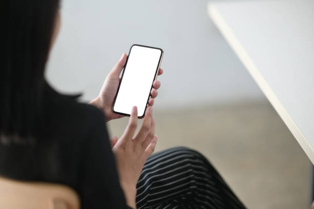 istock Cropped image of hands are using an empty screen smartphone in the living room. 1266909958