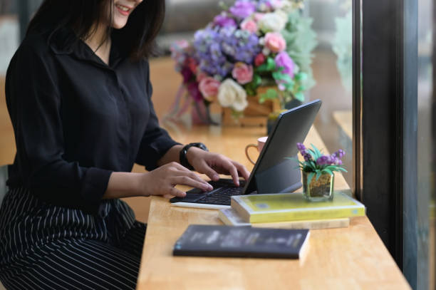 istock A woman is using a computer tablet while sitting at the wooden counter. 1266910052