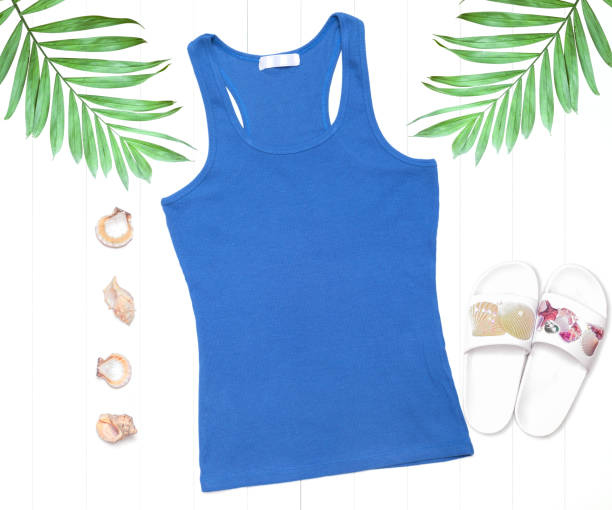 Blue tank top with flip flops and shells on a white background