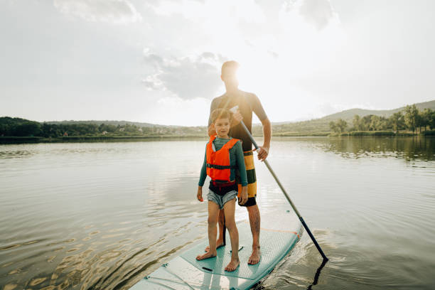 istock Father and son stand-up paddleboarding on the lake 1266918927