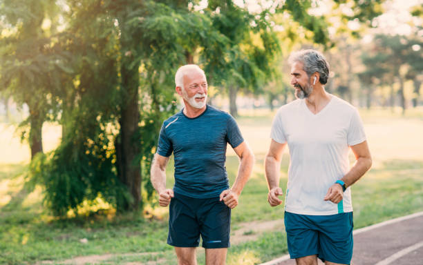 istock Smiling athletes jogging in the park 1266918988