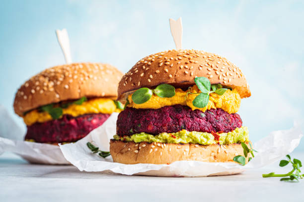 Vegan beetroot burger with sweet potato sauce and guacamole. Plant based diet concept. Vegan burger with beetroot cutlet, sweet potato sauce and guacamole. vegan stock pictures, royalty-free photos & images