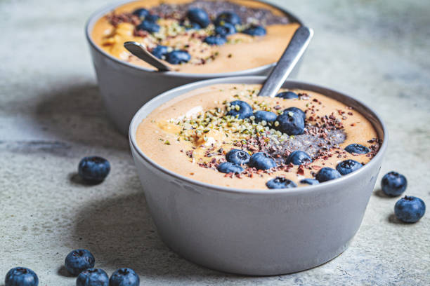 vegansk frukost - chokladmoothieskål med chiapudding, jordnötssmör och bär i grå skål. - yoghurt chocolate bowl bildbanksfoton och bilder