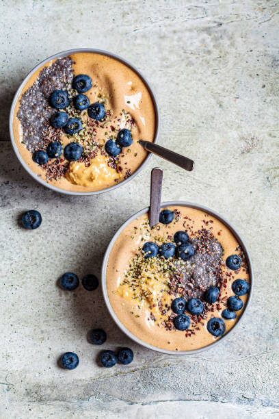 istock Vegan breakfast - chocolate smoothie bowl with chia pudding, peanut butter and berries in gray bowl. 1266921605