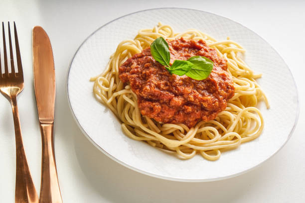 istock Traditional pasta bolognese served on a white plate and garnished with basil 1266923128