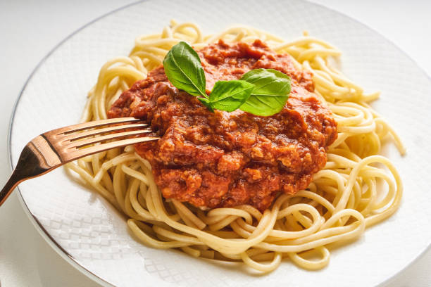 istock Traditional pasta bolognese served on a white plate and garnished with basil 1266923130