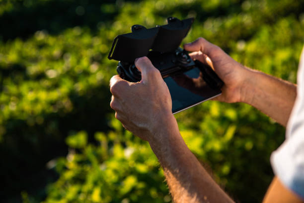 istock A young man in a white T-shirt has a drone controller in his hand. He operates a plane to record agricultural crops. 1266924745