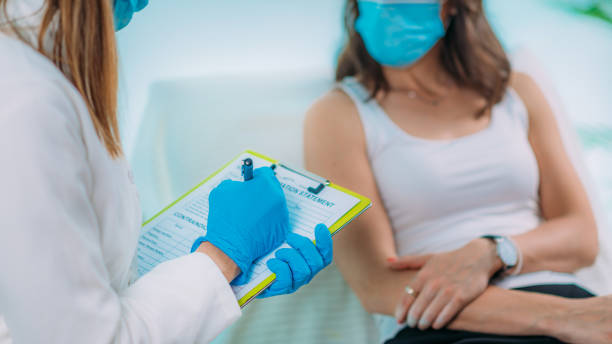 istock Nurse with Protective Mask Filling in Information Form. Blood Drawing and Analysis During Covid19 Coronavirus Crisis 1266926420