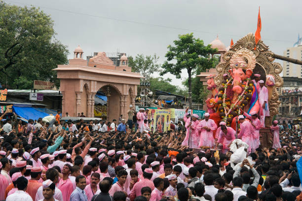 os devotos estão reunidos na rua no dia da procissão pública do festival de ganesha. - ganesh festival - fotografias e filmes do acervo