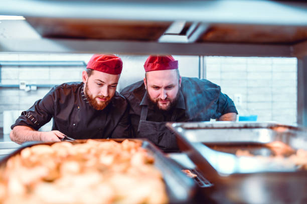 istock Male Bakers Waiting For Fresh Bread To Be Baked 1266929014