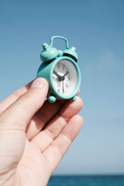 istock man with an alarm clock on the beach 1266930171