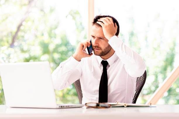 istock Careworn businessman sitting at office desk and working 1266932465