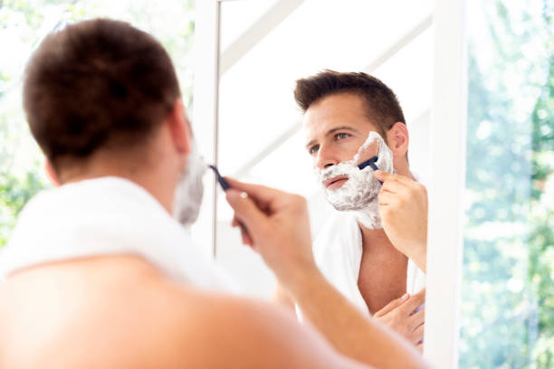 istock Handsome man shaving his face in the bathroom 1266932635