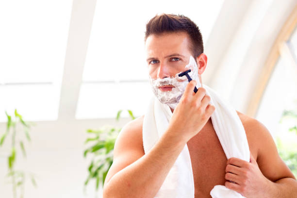istock Handsome man shaving his face in the bathroom 1266932637