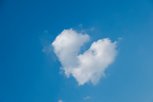 a cloud in the blue sky that looks like a broken heart