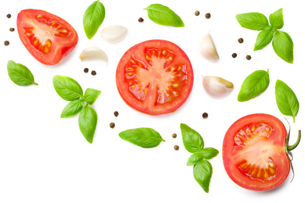 fresh tomato slices with garlic and basil leaves isolated on white background. top view