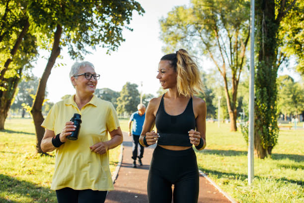 istock Senior woman jogging with instructor 1266937818