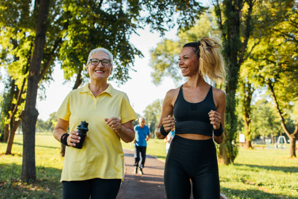istock Senior woman jogging with instructor 1266937819