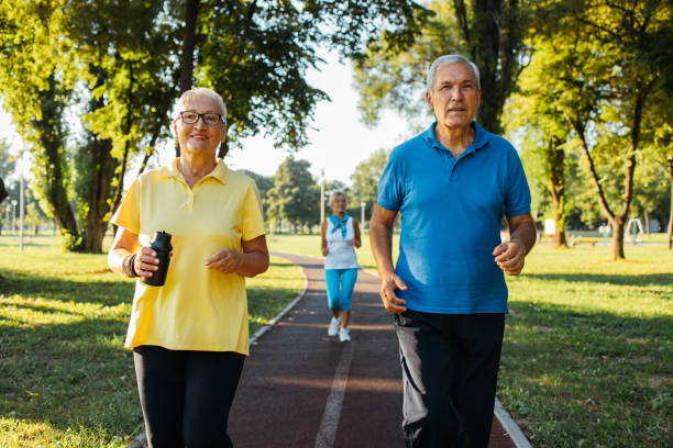 istock Seniors jogging in park 1266937820