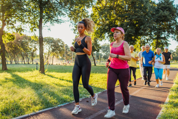 istock Seniors jogging in park with instructor 1266937837
