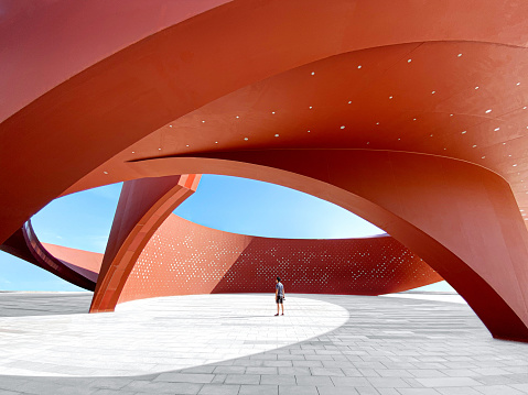Una persona en un espacio arquitectónico abstracto curvo rojo, representación 3D photo