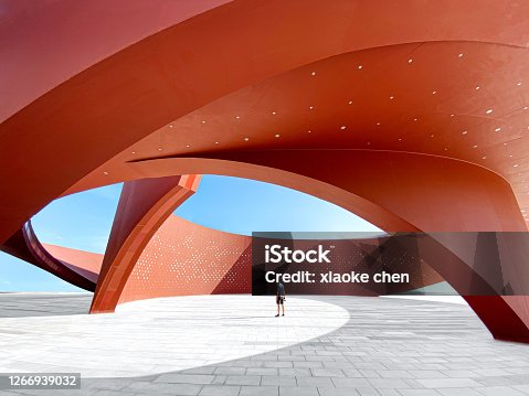 istock A person in a red curved abstract architectural space, 3D rendering 1266939032