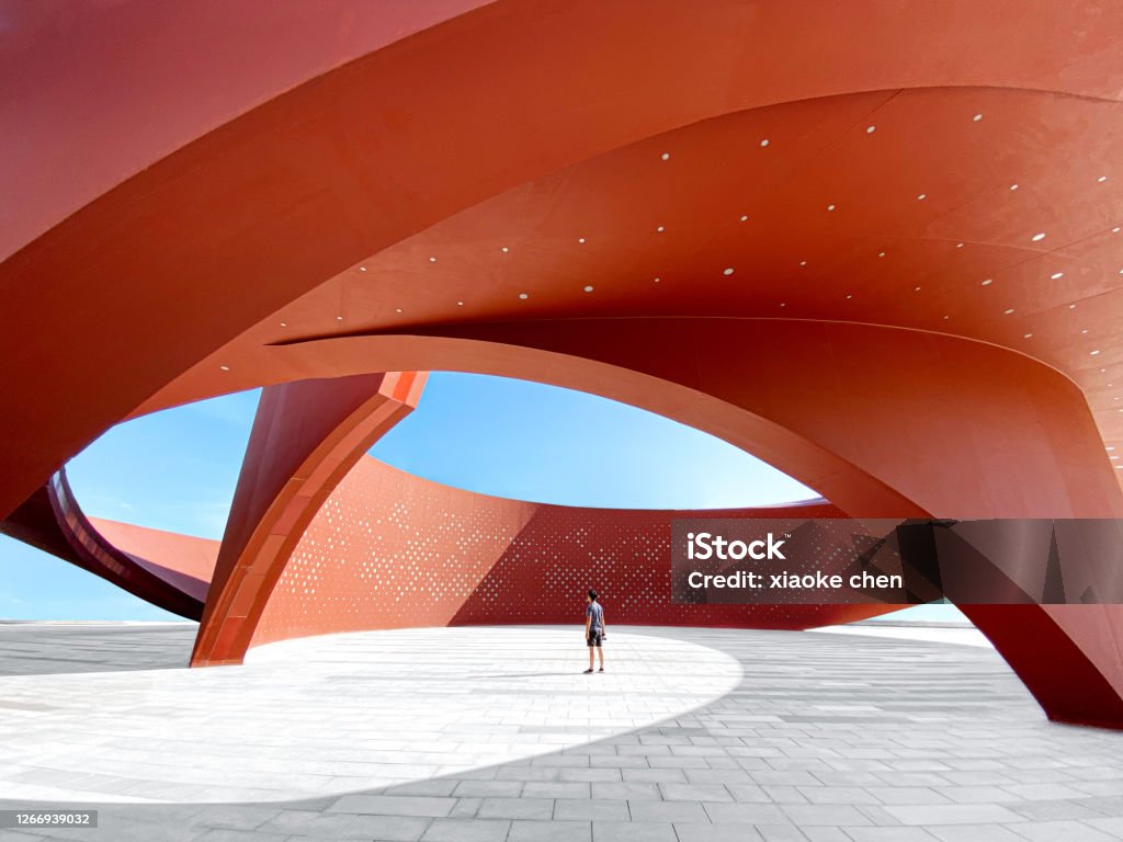 A person in a red curved abstract architectural space, 3D rendering A person standing in a red curved abstract architectural space, 3D rendering Architecture Stock Photo
