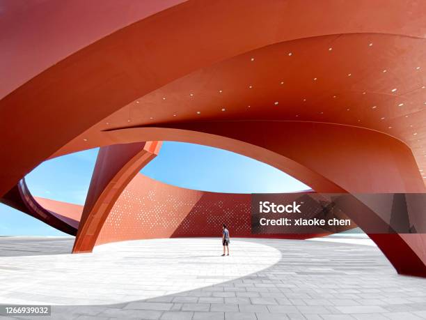 A Person In A Red Curved Abstract Architectural Space 3d Rendering Stock Photo - Download Image Now
