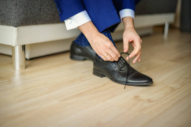 istock Groom is wearing shoes in blue wedding suit 1266939332