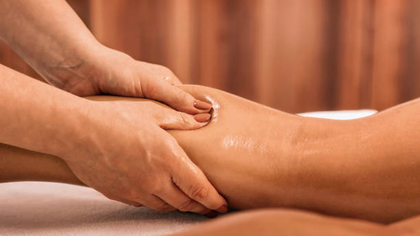 Lymphatic Drainage Massage Lymphatic drainage massage. Hands of a masseuse massaging leg of a female client lymphatic system stock pictures, royalty-free photos & images