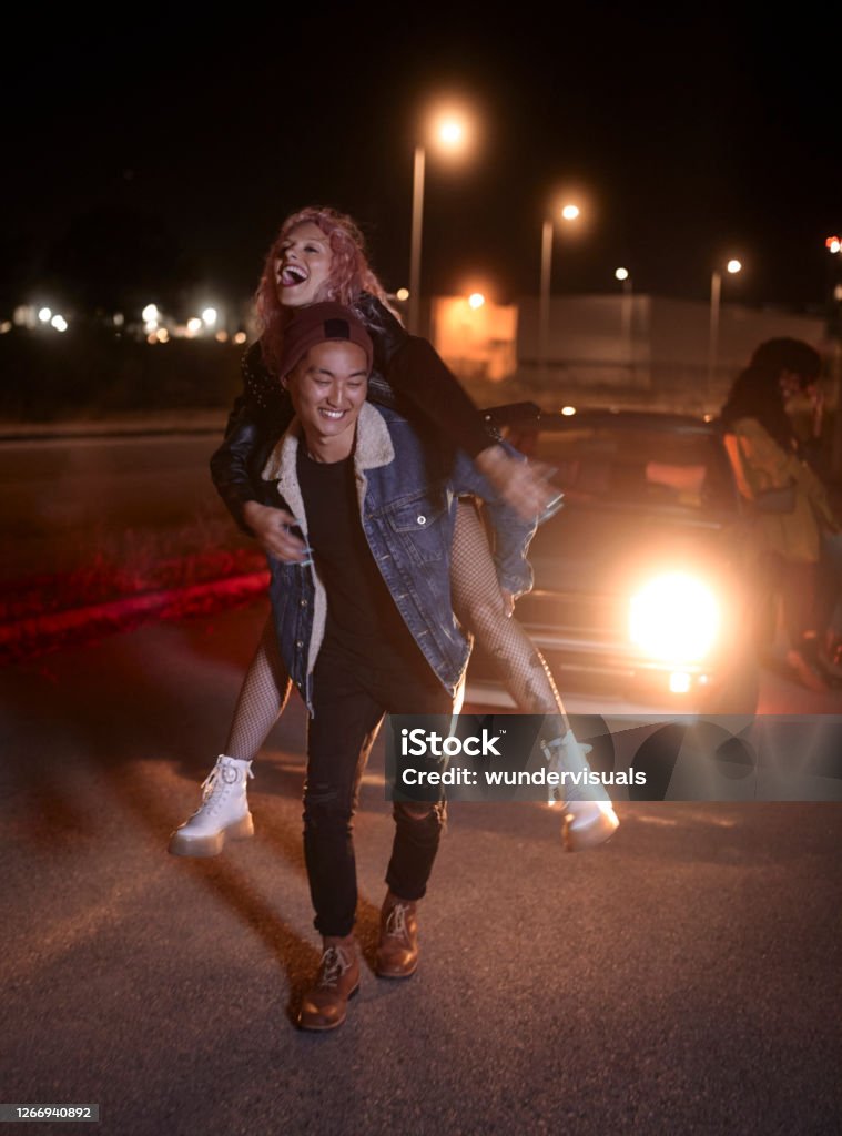 Young Man Giving Girlfriend Piggyback Ride At Night On Parking Lot Stock  Photo - Download Image Now - iStock