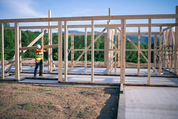 istock Builder walking with wooden beam on shoulder in an unfinished wooden construction site. 1266941283