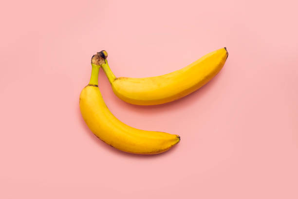 istock Two bananas together on a pink background 1266944507