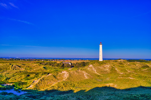 Beautiful sunset at the white lighthouse Lyngvid near Hive Sande in Denmark.