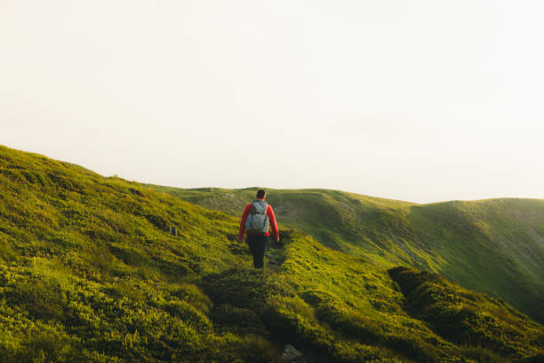 istock Man backpacker having the best time outdoors hiking in the mountains during sunset 1266946814